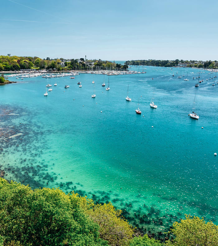 Île de Saint Nicolas des Glénan avec eaux turquoise, voiliers ancrés et végétation méditerranéenne pour séjour multiactivités en famille