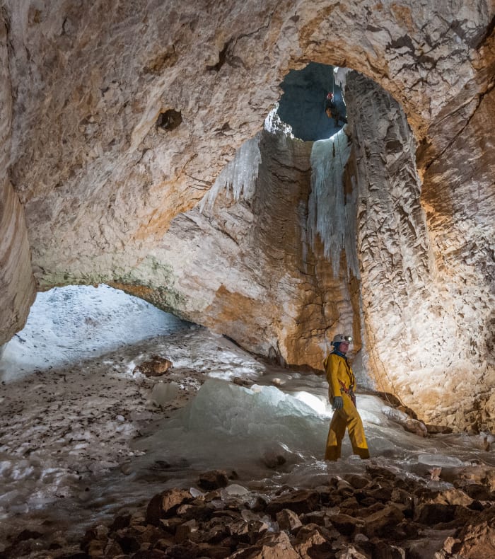 Spéléologue explorant une galerie souterraine du Vercors avec équipement de progression et lampe frontale