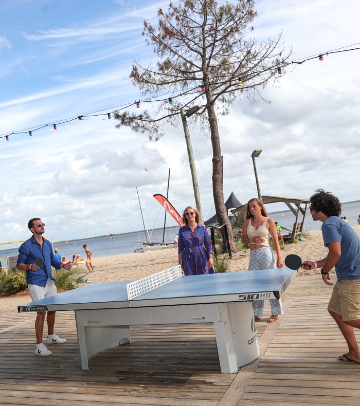 Groupe pratiquant le tennis de table et beach volley sur la plage du domaine de Bombannes en Gironde