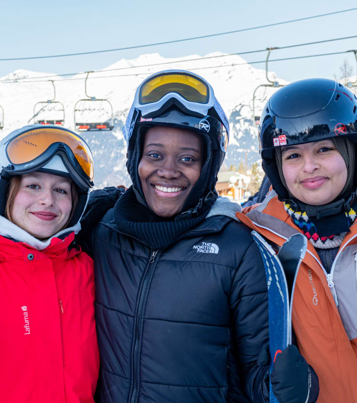 Groupe de skieurs et snowboarders en pause sur les pistes enneigées des Arcs avec vue panoramique sur les sommets alpins