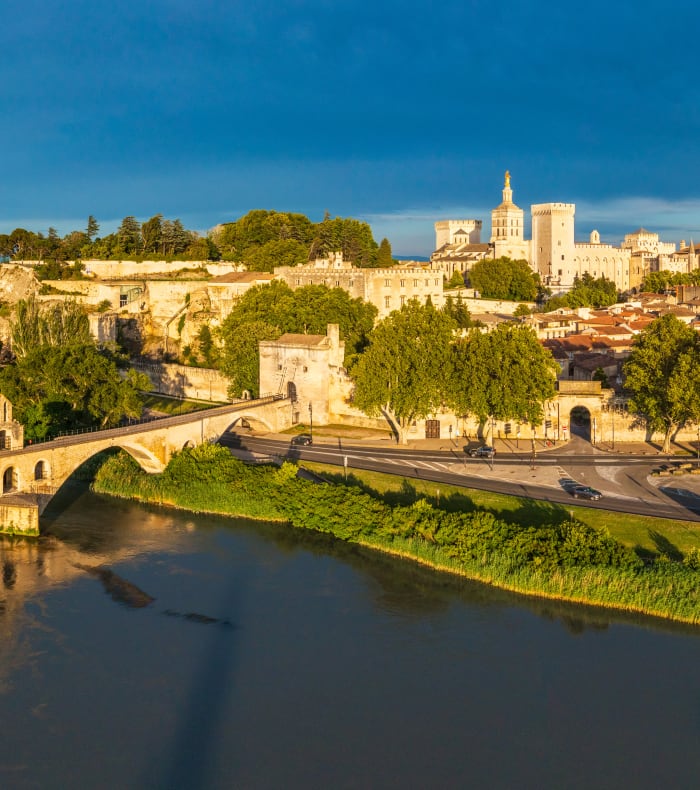 Forteresse médiévale d'Avignon dominan la Provence avec village provençal aux toits ocre sous ciel bleu