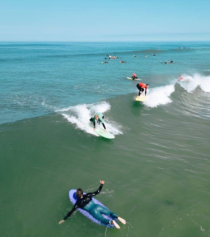 Groupe de surfeurs et wakeboarders profitant des vagues et activités nautiques à Bombannes entre lac et océan