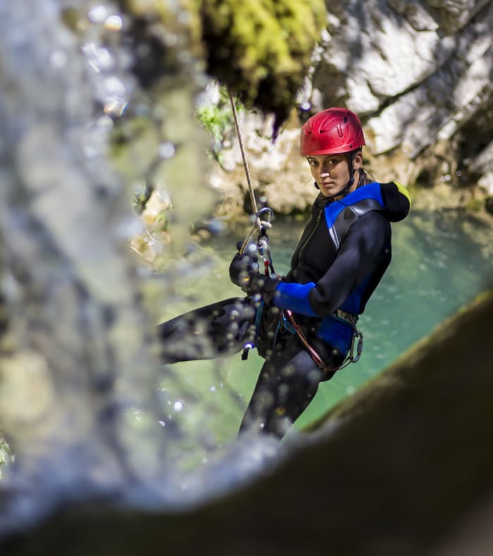 Groupe de randonneurs en trek sur les alpages verdoyants du Mercantour avec falaises rocheuses en arrière-plan