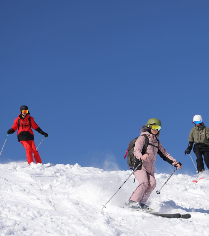Skieur et snowboarder en action sur piste enneigée aux Orres par temps ensoleillé