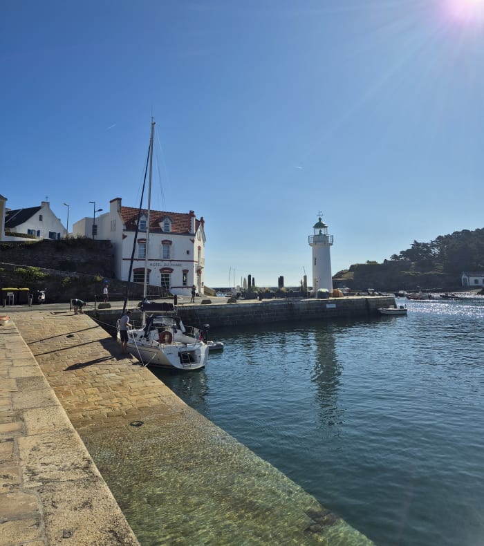 Stagiaire regardant à l'horizon assise sur un voilier habitable en navigation en Bretagne, séjour Objectif voilier niveau 1