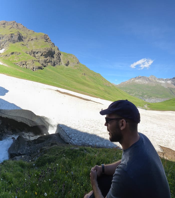 Randonnée en Haute-Maurienne avec cascade alpine, névés persistants et paysage montagnard sous ciel bleu