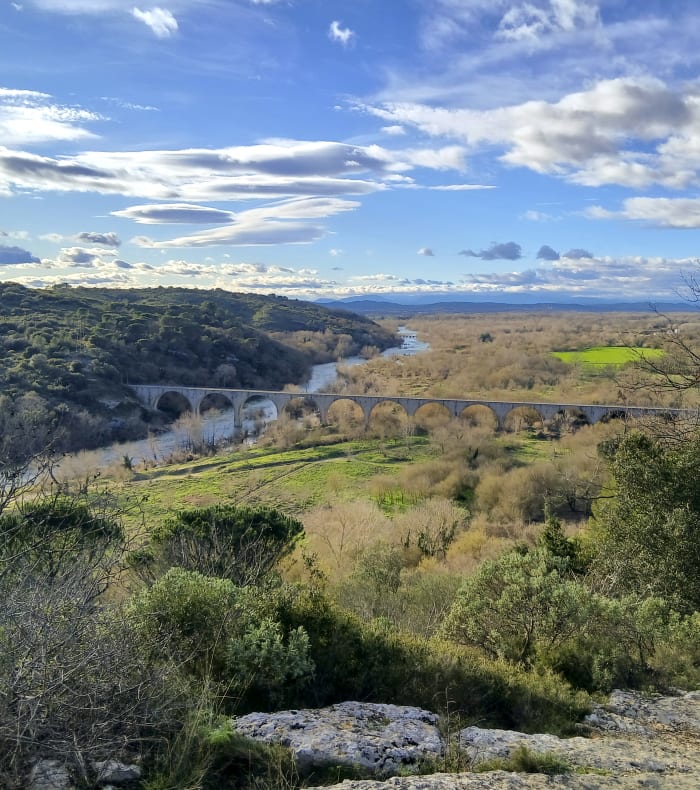 Vue panoramique des Gorges du Gardon avec pont en pierre, rivière et paysage méditerranéen verdoyant