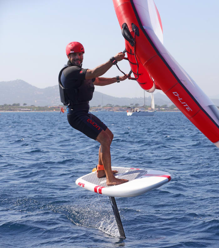Pratiquant de wingfoil en action sur la Méditerranée avec wing rouge et planche blanche, Camargue
