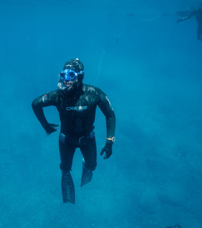 Apnéiste en combinaison noire et masque de plongée explorant les eaux turquoise de Lanzarote
