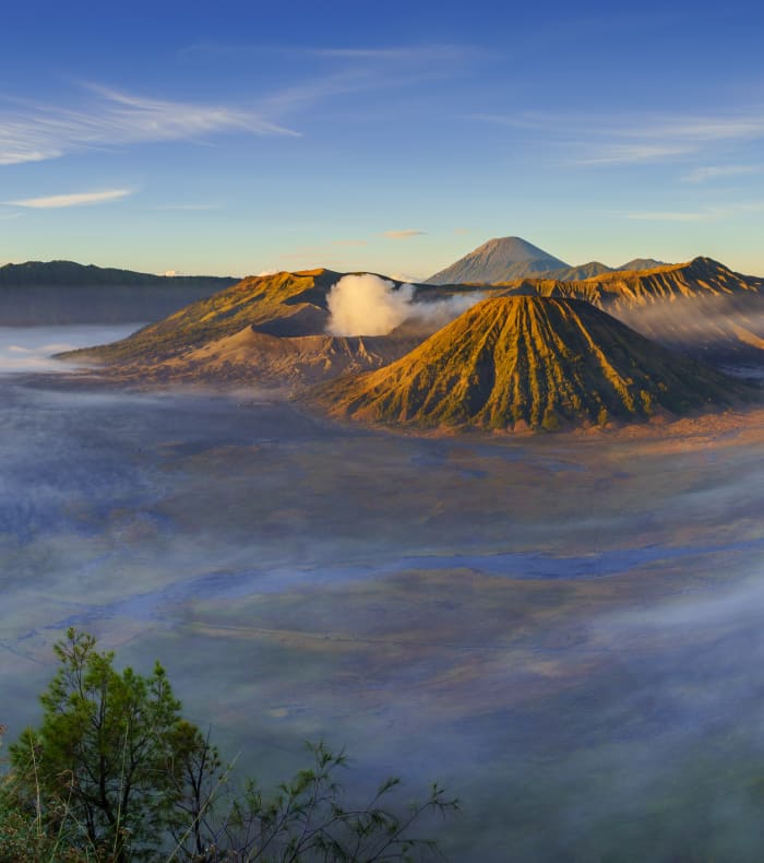 Volcans du Bromo à Java enveloppés de brume matinale avec paysage montagneux et vegetation tropicale