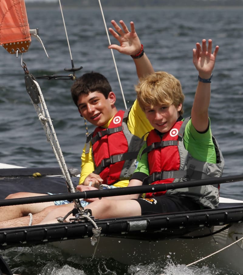 Enfants en gilets de sauvetage pratiquant les sports nautiques sur un catamaran au lac de Bombannes lors d'une classe de mer