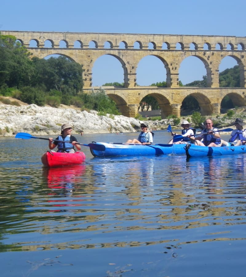 Groupe en kayaks bleus et rouges sur le Gard face au Pont du Gard en Provence