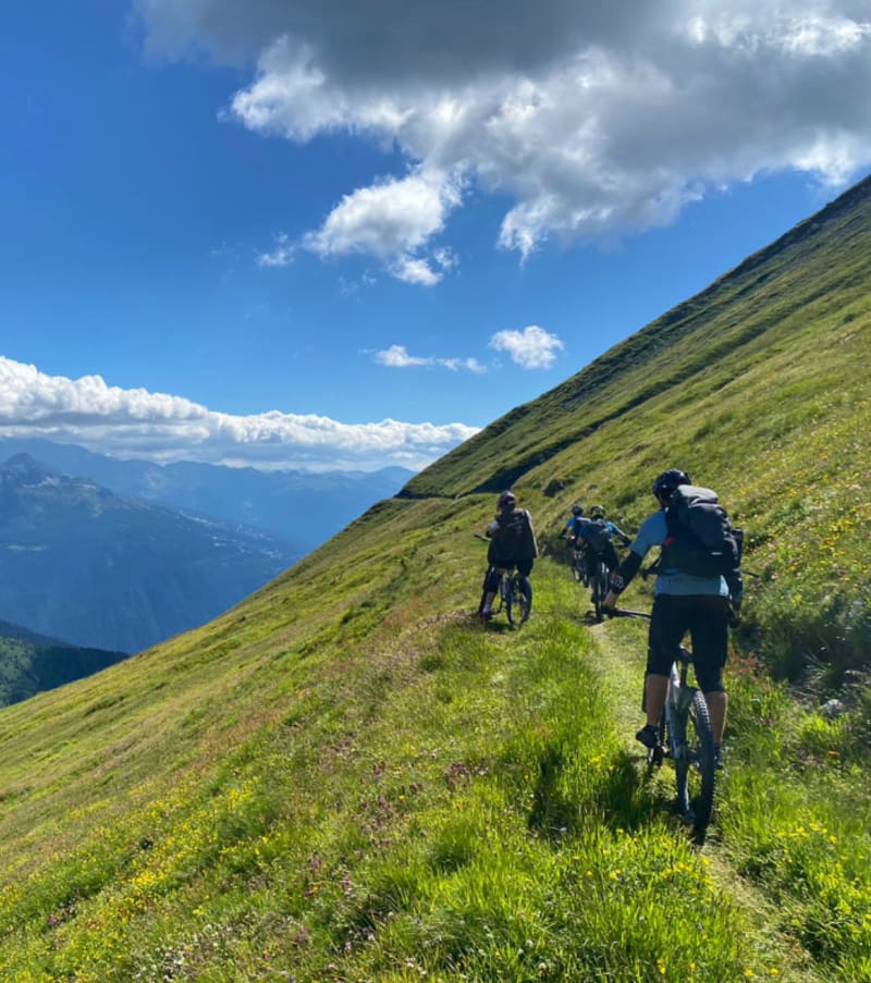 Groupe de cyclistes en randonnée sur chemin à flanc de montagne