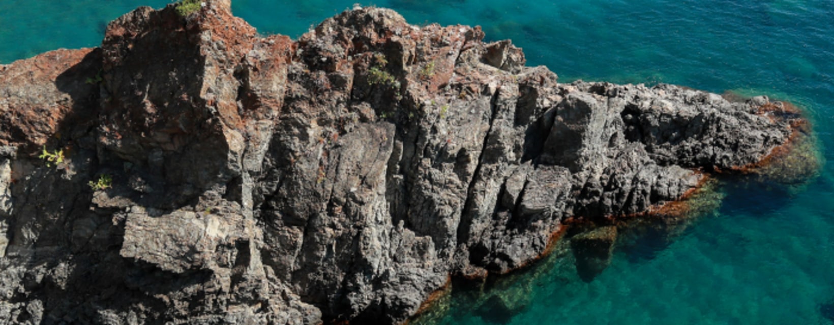 Côte rocheuse de Saint-Cyprien avec eaux turquoise et kayak, idéale pour activités aquatiques en groupe