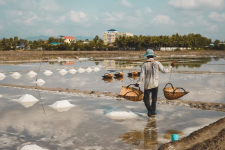 Homme qui travaille dans les champs de sel à Kampot, au Cambodge