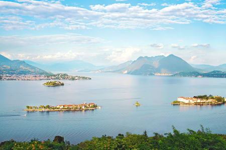 Vue sur les îles Borromes au milieu du Lac Majeur en Italie avec en arrière-plan les montagnes environnantes.
