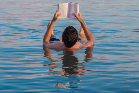 Une personne lisant un livre dans la Mer morte, Jordanie
