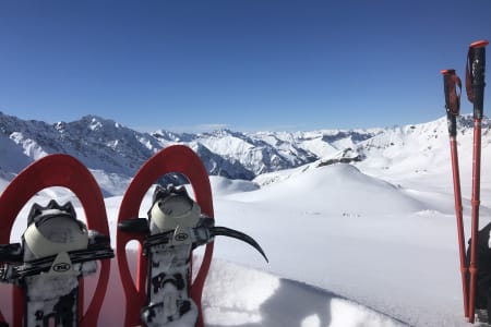Paire de raquettes plantés face aux montagnes enneigées des Écrins