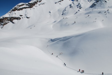Tracé d'un groupe de raquetteurs dans la montagne enneigée du Queyras