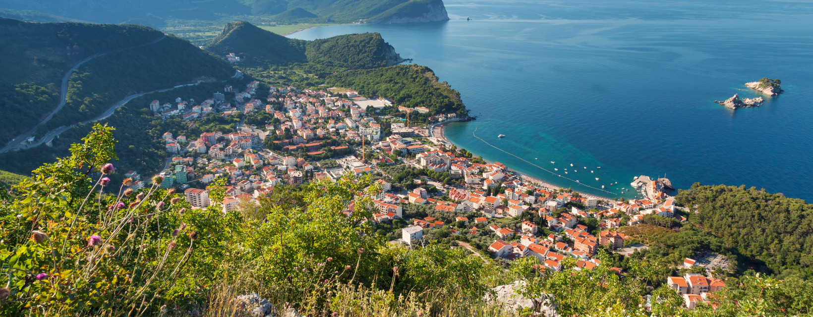 Panorama sur la ville de Petrovac au Monténégro avec des montagnes verdoyantes en arrière plan et la mer Adriatique