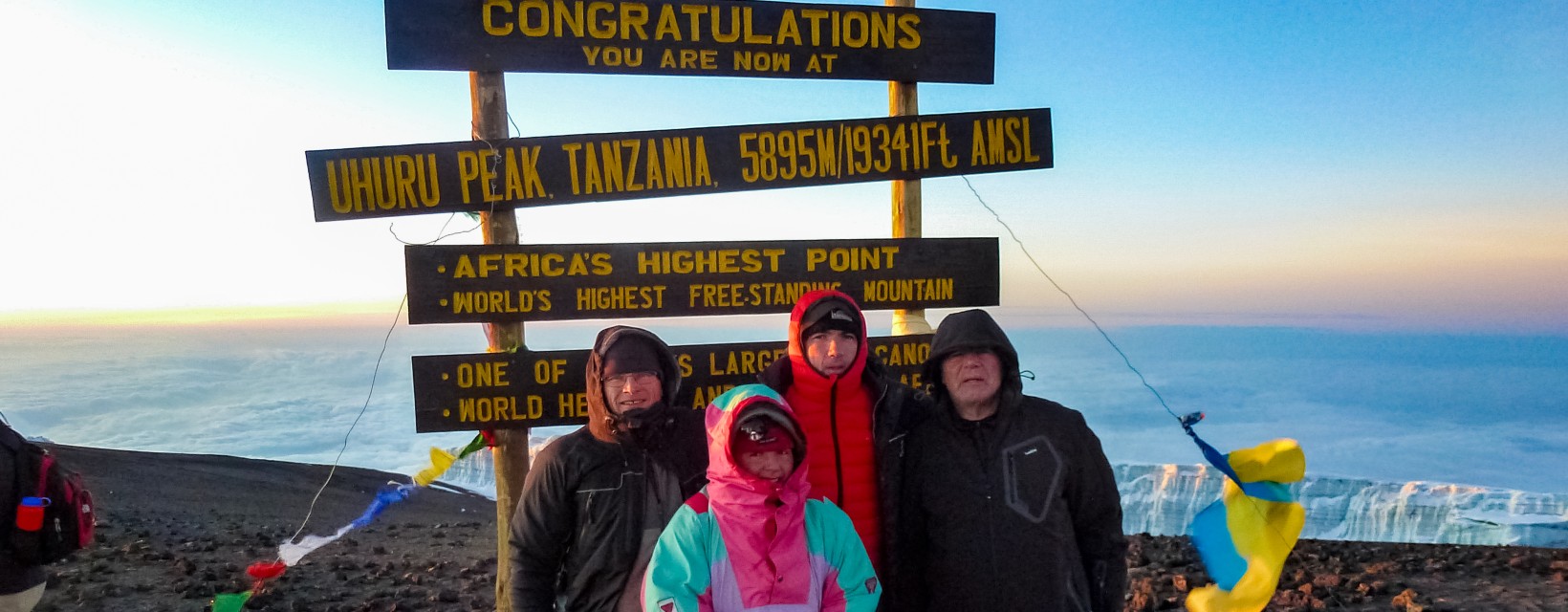 Quatre personnes se trouve sur le sommet du Kilimandjaro, plus haut sommet d'Afrique