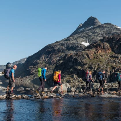 Traversée de rivière, en arrière plan le Pic Uranostind, Jotunheimen, Norvège