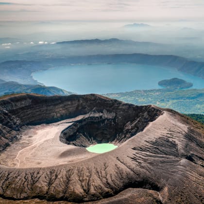 Aerial view of Santa Ana Volcano with lake and mountain cloud backdrop