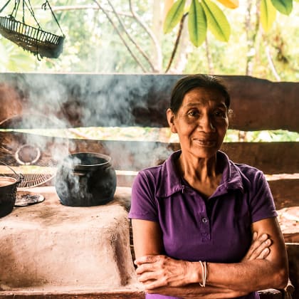 Latin grandmother with crossed arms smiling at camera in the kitchen of her house in Nueva Guinea, Nicaragua