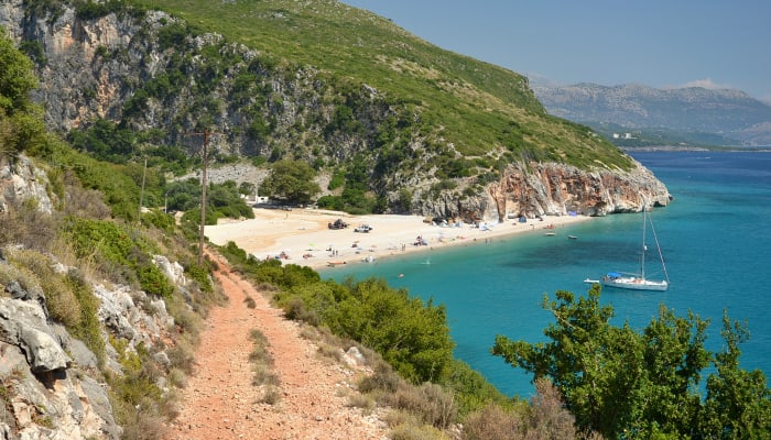 Sentier menant et surplombant une plage turquoise en Albanie