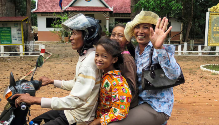 Famille souriant sur un scooter, Cambodge