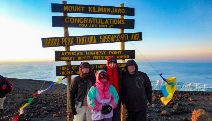 Quatre personnes se trouve sur le sommet du Kilimandjaro, plus haut sommet d'Afrique