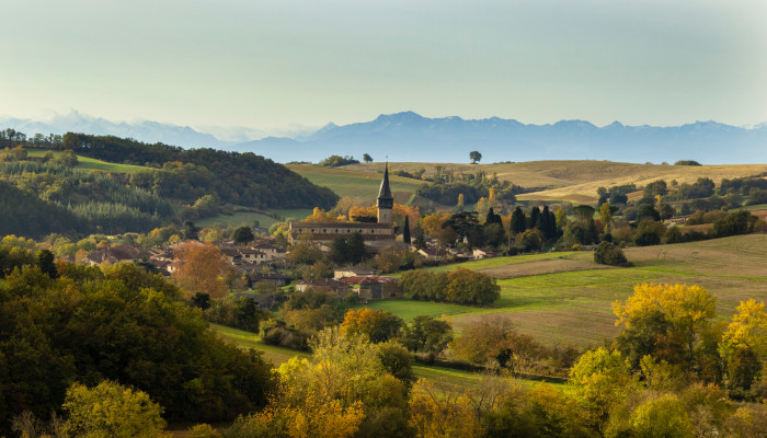 Village de Barran en automne dans le Gers, avec la chaîne des Pyrénées en arrière plan